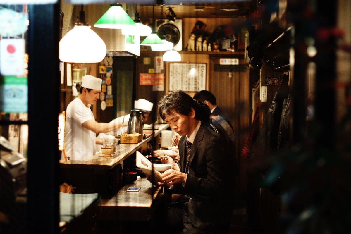 man eating at asian restaurant