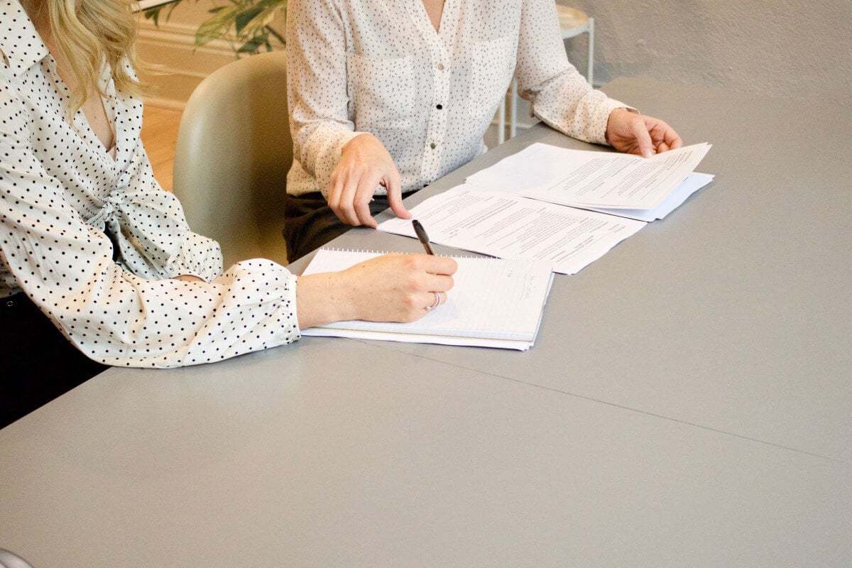 women reviewing catering business license application paperwork